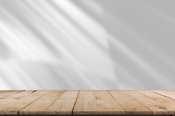 Empty of wood table top on abstract White concrete wall with  sunlight shadow reflected. For montage product design display mockup