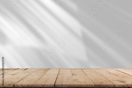 Empty of wood table top on abstract White concrete wall with  sunlight shadow reflected. For montage product design display mockup