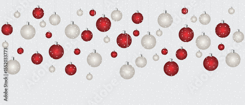Christmas themed ornaments hanging on strings. There are alternating red and white baubles with polka dots on them. These are set against a background of snowfall.