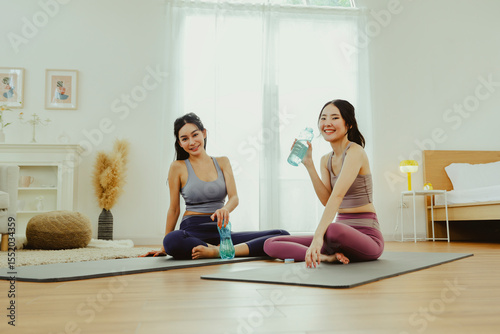 Wallpaper Mural Happiness of two young women who are close friends, talking while exercising, sitting and drinking water to refresh themselves, making them cheerful and smiling. Torontodigital.ca