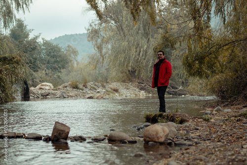 hombre disfrutando de un día de paseo en el bosque en temporada de otoño junto al río