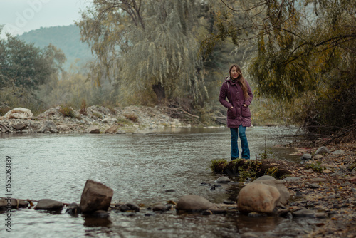 mujer disfrutando de un día de paseo en el bosque en temporada de otoño junto al río
