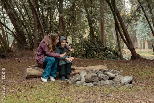madre e hijo felices juegan simulando estar en una fogata en un día de otoño