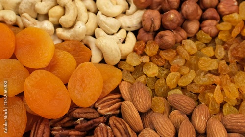 Mix nuts and dried fruits top view, rotation. Healthy vegan snack ideas