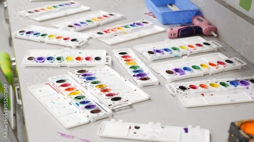 Watercolor palettes and supplies on table
