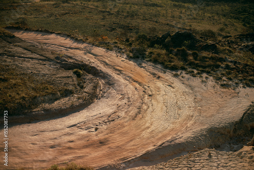 Curved path with dry and cracked soil, crater.
