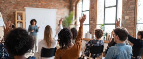 The engaged audience raises hands during an interactive workshop session.