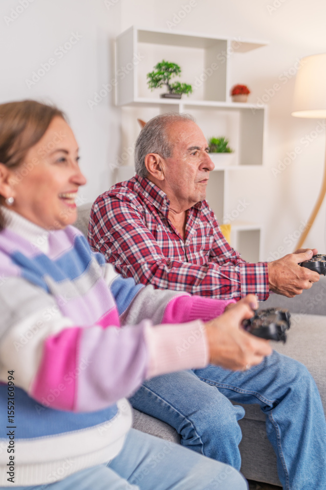 Obraz premium Senior couple playing videogames at home having fun