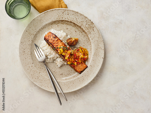 Delicious Grilled Salmon Served With Rice and Fresh Salsa on a Ceramic Plate