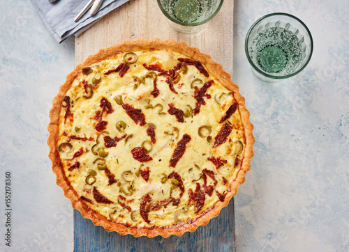 Savory Tart With Olives and Sundried Tomatoes on Wooden Surface Ready for Serving