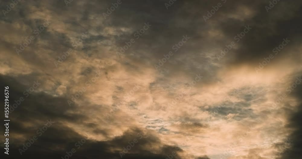 Timelapse of the sky with multiple layers of clouds first romantically tinted by the light of setting sun and then gradually getting darker and more dramatic and denser