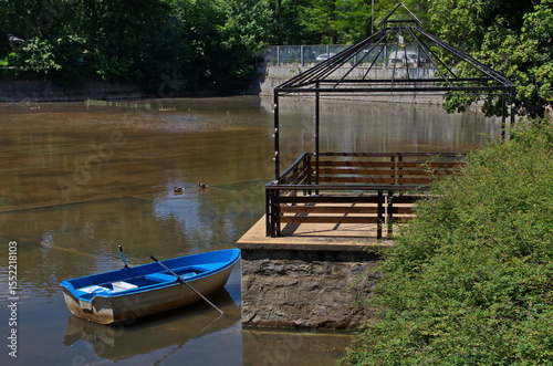 Cozy relaxation area with fresh spring trees, a pontoon, a gazebo and a boat for a walk in Lake Ariana, Borisova garden, Sofia, Bulgaria   