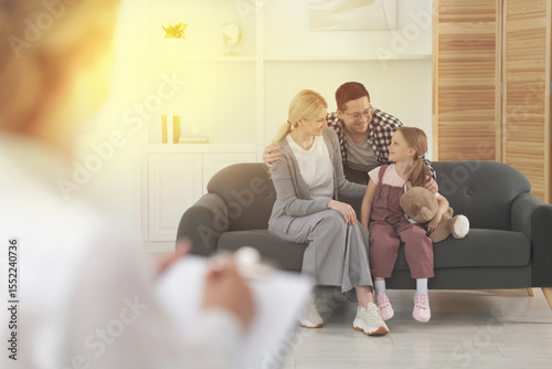 Happy family having consultation with psychologist in office, selective focus