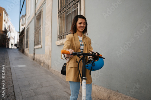 Young Asian woman driving e scooter and exploring town