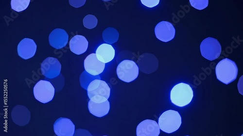 Abstract glowing blue bokeh lights on a dark background, creating a festive, dreamy, and ethereal atmosphere for celebrations or digital design.