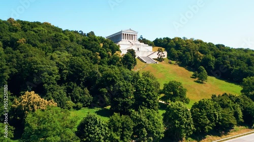 Walhalla memorial near Regensburg captured from a drone on a sunny day, perched above the Danube River with classical architecture and panoramic views of the Bavarian countryside