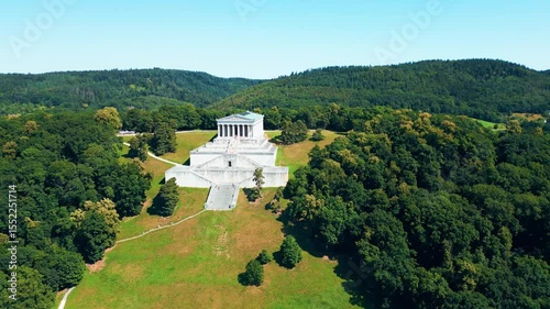 Walhalla memorial near Regensburg captured from a drone on a sunny day, perched above the Danube River with classical architecture and panoramic views of the Bavarian countryside