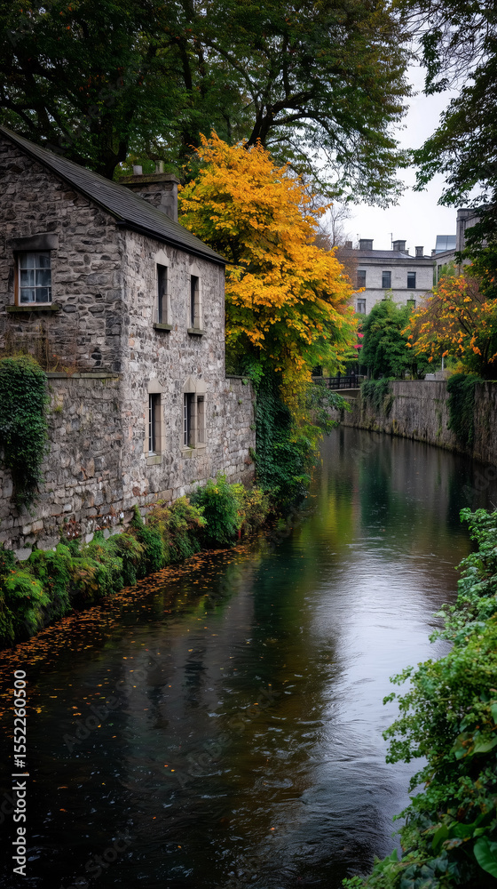 Obraz premium A picturesque stone house on a river during autumn