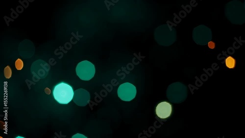 Abstract pattern of blurred green and orange bokeh lights on a dark background, creating a soft, dreamy atmosphere for festive and decorative themes