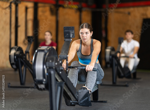 Konstfotografi Woman performs exercises on a rowing machine, keeping the pace