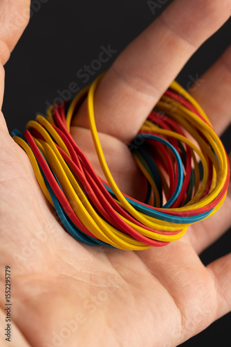 multi-colored rubber bands for office or money, empty scattered thin rubber bands of different colors for packaging and organizing paper money, rubber bands to hold in your hands