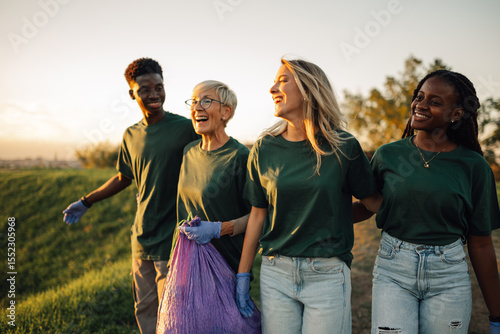 Canvas Print Group of volunteers collecting garbage in park are walking and talking