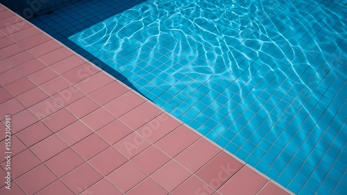 Abstract view of a swimming pool edge with pink tiles and rippling blue water