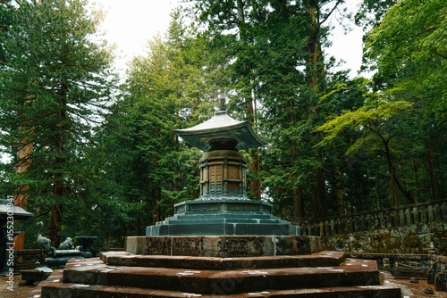 Traditional Japanese stone pagoda in a serene forest setting at Tosho-gu, Nikko, Japan
