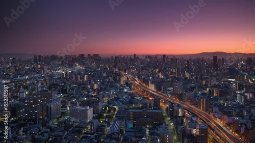 osaka city slyline aerial shot time lapse from night to day,high view of metropolis cityscape at sunrise