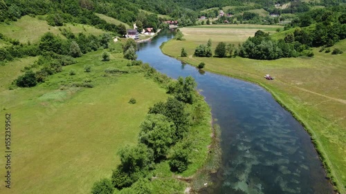 A river flows in a field. Clear river, drone shot.
