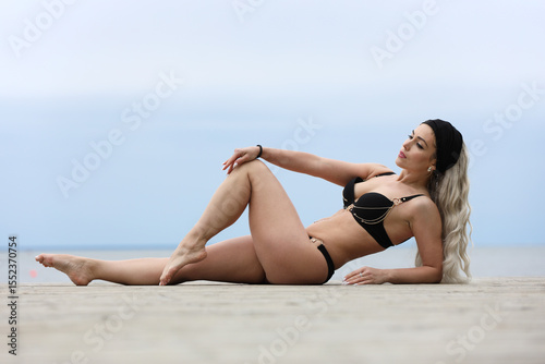 Sensual Woman in Black Swimsuit Relaxing on Sunny Beach