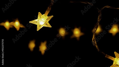 Christmas Stars garland on black background.shining yellow stars garlands. 4k footage