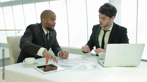 Two businessmen engaged in a dynamic discussion over important documents