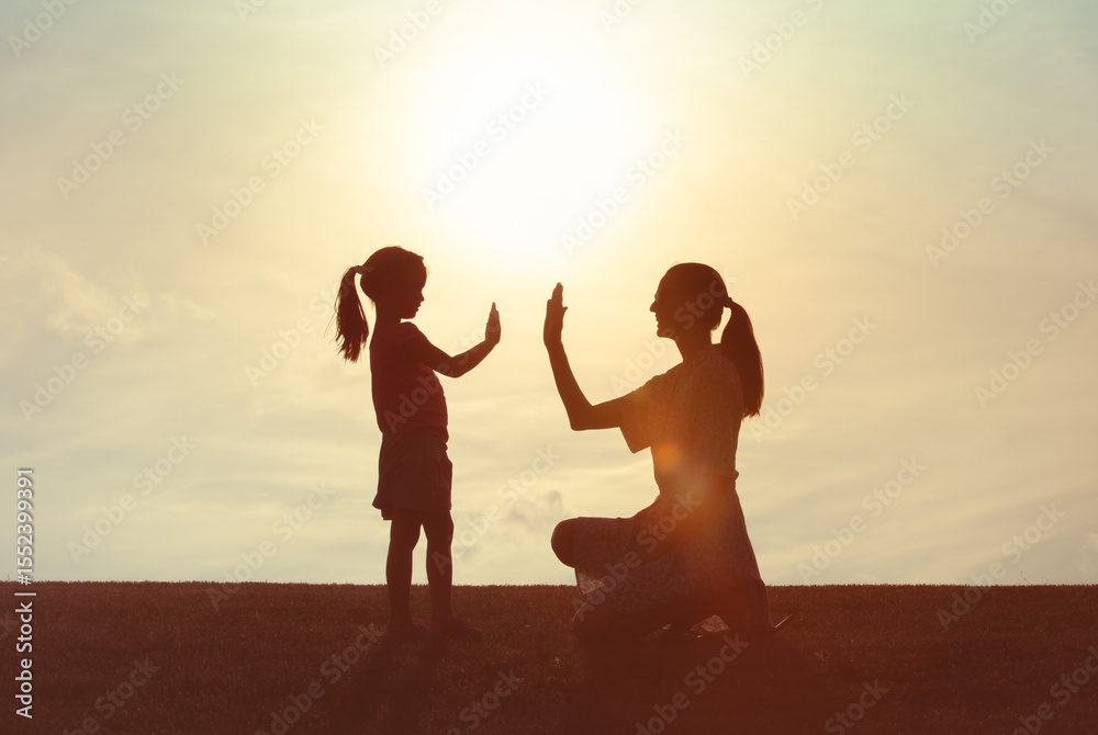 Fototapeta premium Mother giving daughter high five. Parent child relationship concept. Family support, childhood, trust togetherness, bonding, Love, motherhood concept