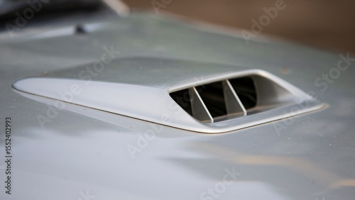Close up of a car ventilation grille on the hood of a car