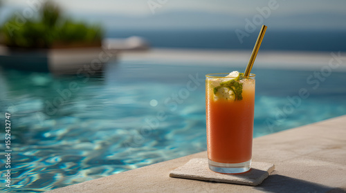 Refreshing summer beverage by the pool, featuring a metal straw and citrus garnish. Relaxing poolside lifestyle.