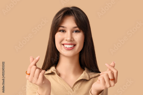 Smiling young woman making ...