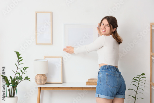 Young woman hanging blank f...