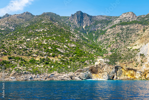 Famous Seychelles beach dramatic landscape and people tourists on Ikaria island, Greece longevity blue zone by Icarian sea ocean water
