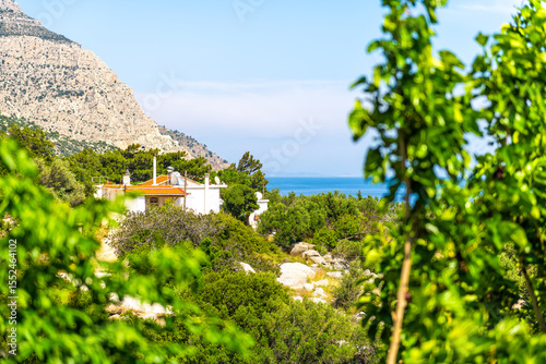 Magganitis town small Greek fishing village at Ikaria island Greece longevity blue zone, home house garden with mulberry fruit trees and mountains