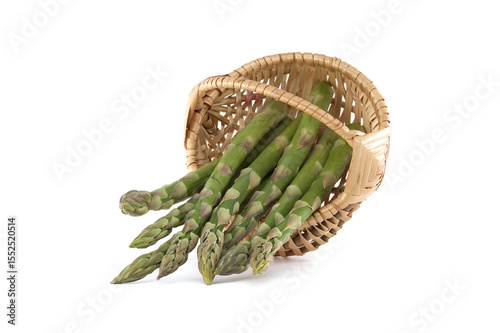 Fresh asparagus spilling from a woven basket on a white background.