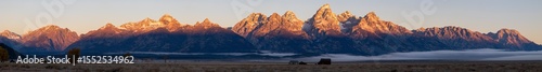 First morning light on the Teton mountain range wih Mormon row in the foreground