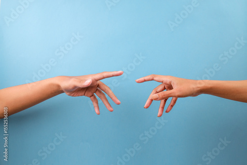 Two Hands Reaching Out To Each Other Over Blue Background
