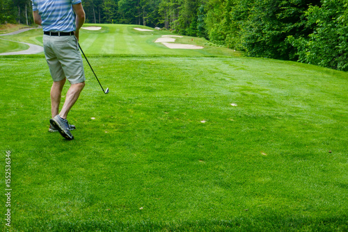man teeing off on golf course