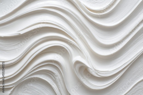 Abstract image of swirling, creamy white substance, creating a smooth, flowing texture with varying levels of depth and light