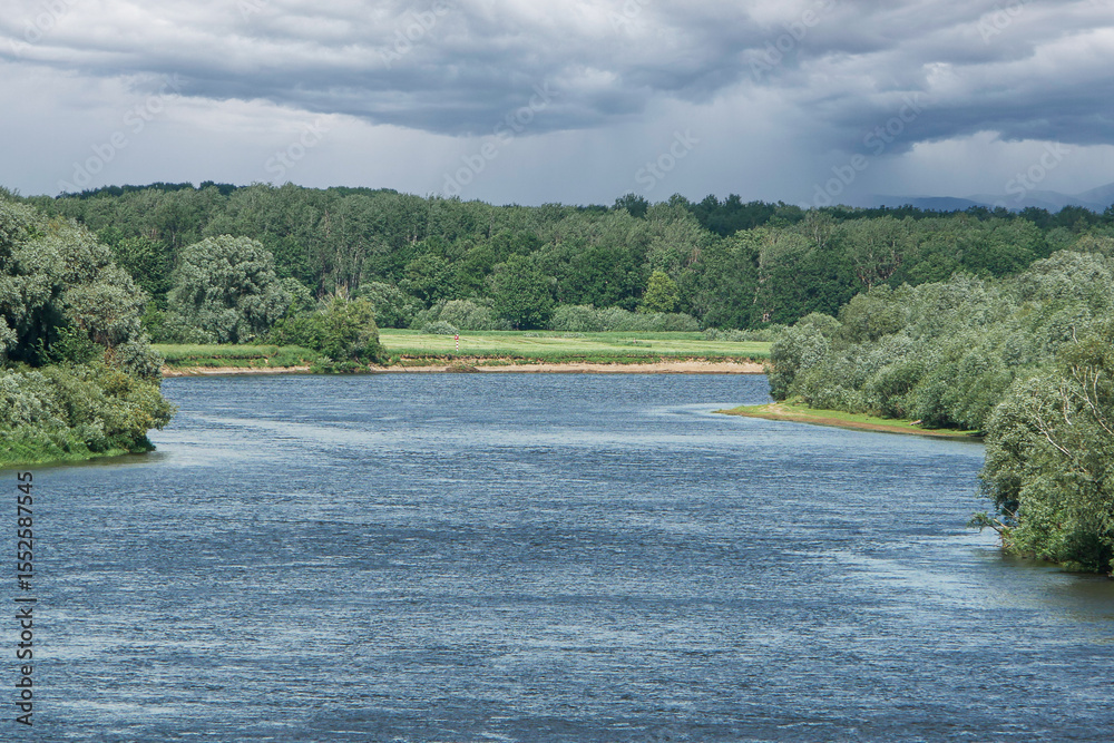 Fototapeta premium Big blue river in a green forest.