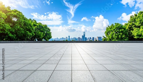 Cityscape Vista: A vast, empty plaza stretches towards a modern cityscape under a vibrant blue sky dotted with fluffy clouds, framed by lush green trees.