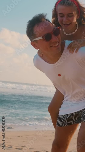 A young couple relaxes by the ocean, sharing laughter and joy as they embrace the warmth of the sun. Their playful interactions create a memorable seaside experience.
