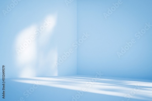 Elegant contemporary natural light shadow on wall in shade of blue for organic beauty cosmetic and skin care product display background
