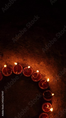Vertical video of Indian festival Diwali, Closeup Festival Diya or Oil Lamp with Glowing Flame, diwali festive of light celebration background animation for social media story.